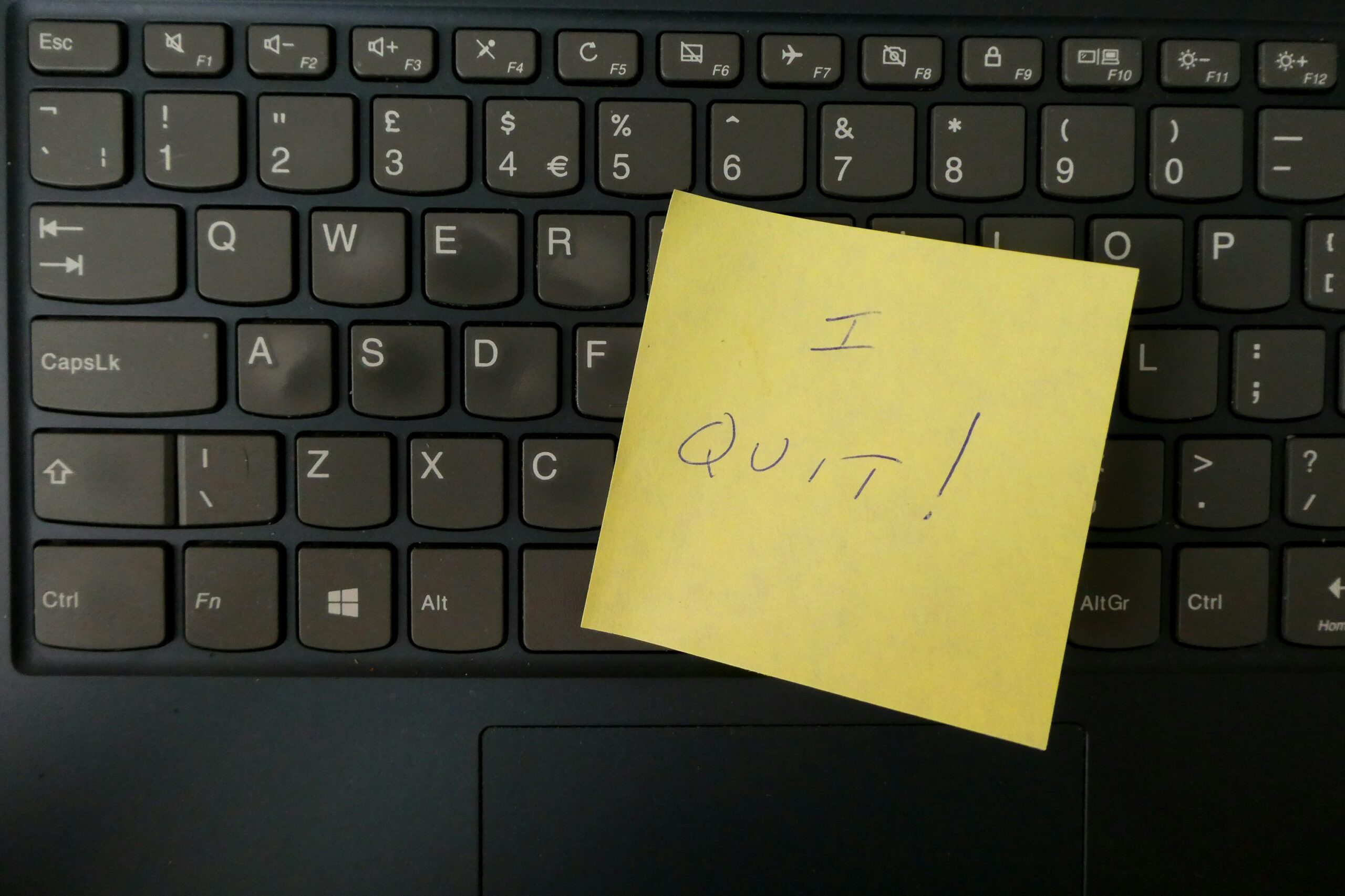 Post it note saying "I quit!" stuck on a laptop keyboard.